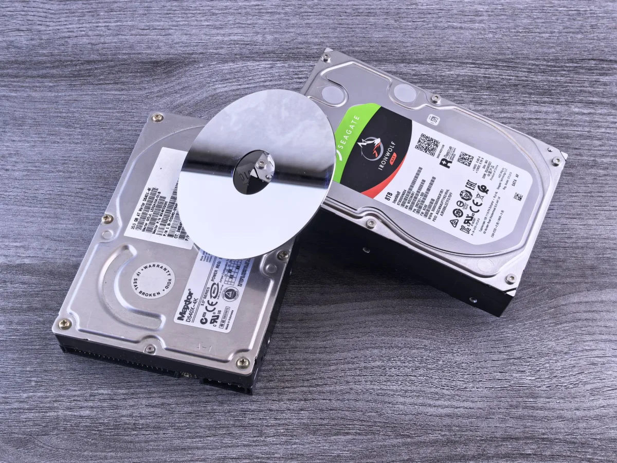 Two external drives—one SSD, one HDD—side by side on a wooden desk.