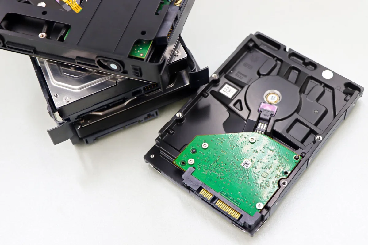 Disassembled hard drives and SSDs laid out for inspection.