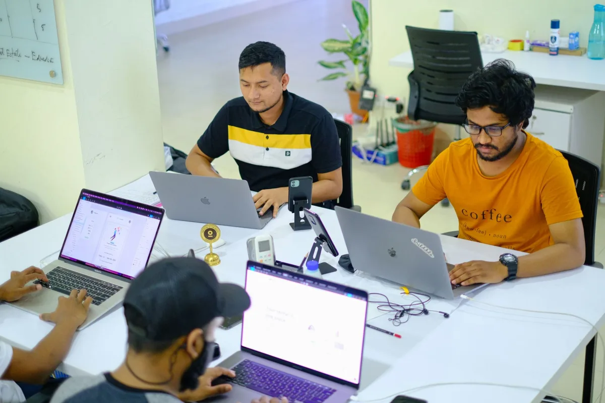 Team of professionals collaborating over laptops in a modern office